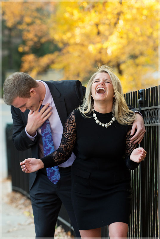 Girl laughing as her boyfriend adjusts his tie.