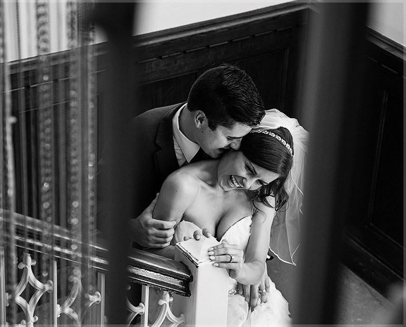 groom kissing his bride on stairs