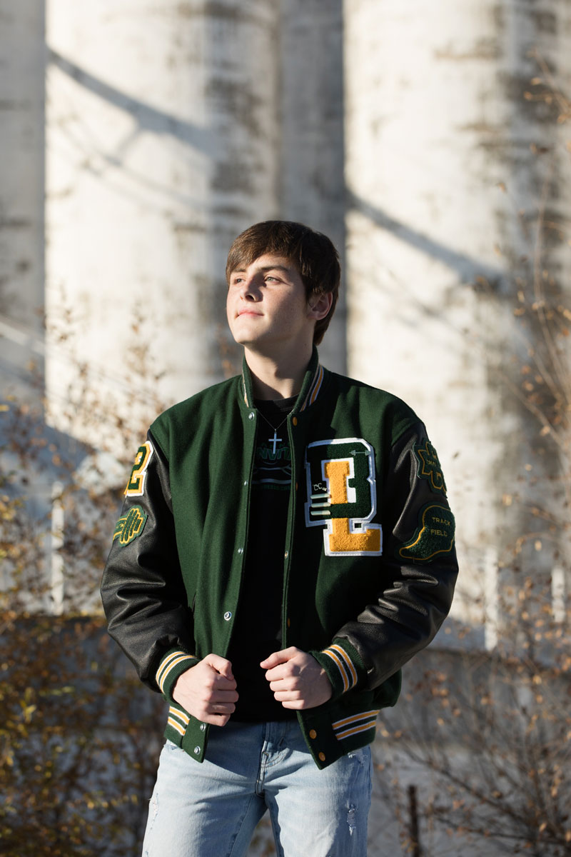 photograph of senior boy in an urban setting and letter jacket