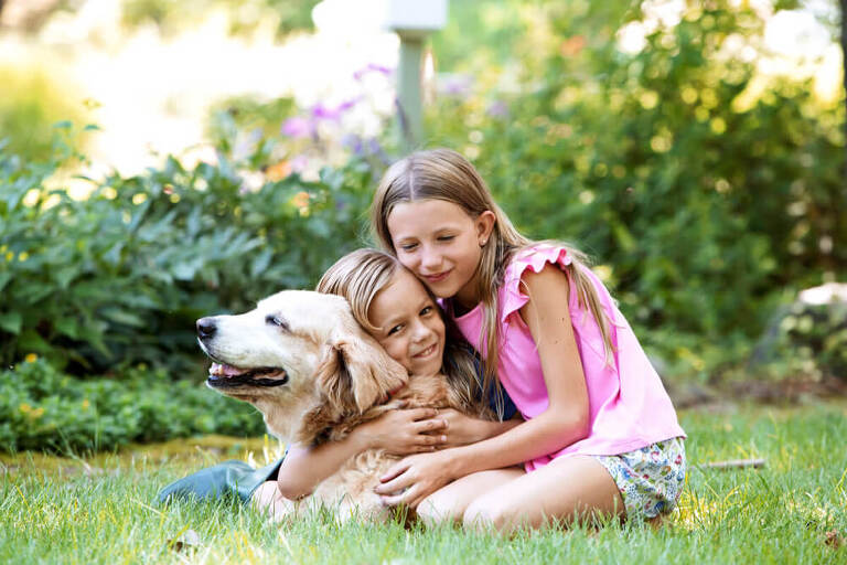 photograph pf brother and sister hugging dog