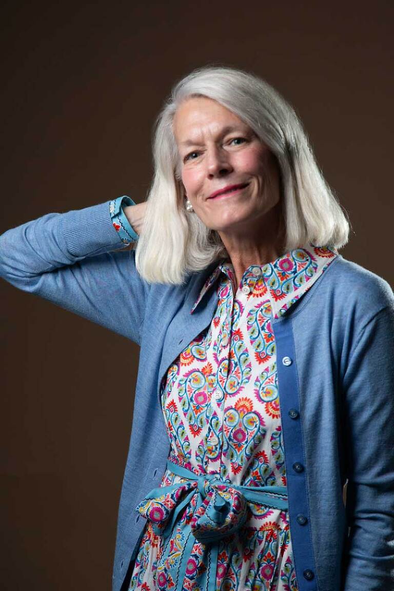modeling headshot of older blond woman wearing blue cardigan